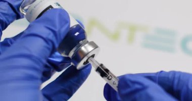 Odessa, Ukrayna - 9 Aralık 2020: Koronavirüs Sars-cov-2 'ye karşı yeni bir aşı ve şırınga bulunduruyor. Bir uyuşturucunun geliştirilmesi ve test edilmesi