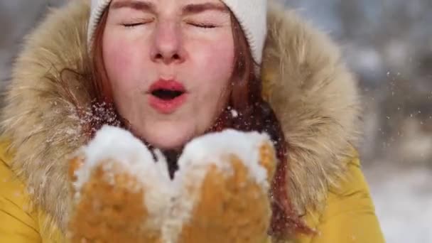 Vacker vinterkvinna blåser snö på vintern i skogen. Begreppet med solnedgång ljus natur på bakgrunden — Stockvideo