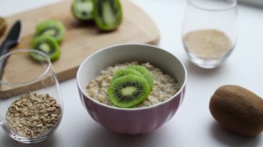 Ev yapımı yulaf ezmesi, müsli, kivi ve esmer şeker. Sağlıklı bir sabah kahvaltısı.
