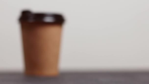 Mengambil cangkir kopi kraft dengan tutup plastik untuk mengisi energi di pagi hari — Stok Video