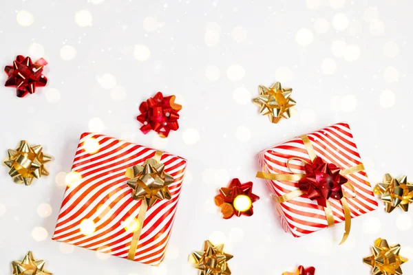해피 뉴얼 프레임 구성. 크리스마스 줄무늬 디자인 선물 상자, 황금색과 붉은 색 공, 복사 공간이 있는 흰색 배경에 반짝 이는 빛. 평평하게 누워 있는 위에서 바라본 모습 — 스톡 사진