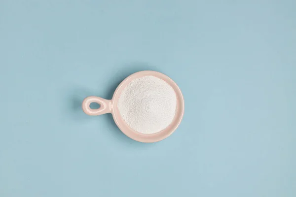 蓝色背景的粉红碗中的胶原粉或蛋白质 顶部视图 化妆品护肤概念 — 图库照片