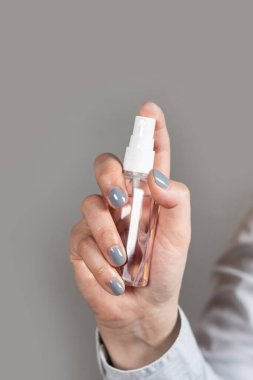 Kadın elleri alkol şişesi dezenfektan kullanıyor mikropların, bakterilerin ve virüslerin yayılmasını önlüyor.