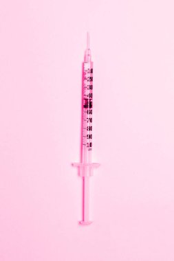 Pembe arka planda tıbbi şırınga. Sağlık ve aşı kavramı. Kozmetoloji. Düz konum, kopyalama alanı.