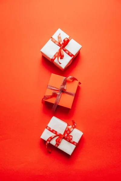 Tarjeta de felicitación de San Valentín con cajas de regalo rojas y lazo de cinta decorado sobre fondo rojo — Foto de Stock