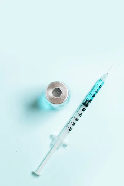 薄青の背景にガラス瓶の薬で輝きます インフルエンザに対するワクチン Covid コロナウイルス病 予防接種の概念 — ストック写真