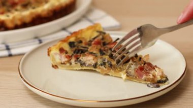 Pastırmalı, mantarlı, soğanlı ve çatallı ev yapımı turtayı yakın çekimde ye.