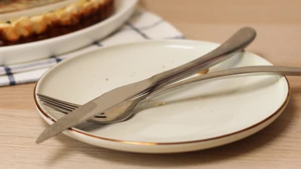 ナイフで汚れたプレートを空にし、テーブルの上にフォーク。女の手は食べ物の後に汚れた料理を取る — ストック動画