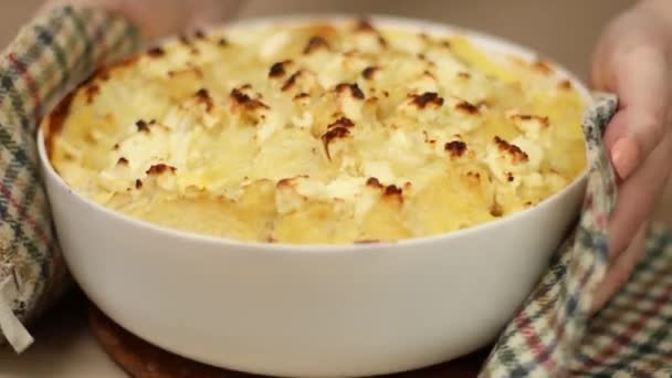 Les mains féminines mettent le plat avec la tarte fraîchement cuite. Plat de casserole de chou-fleur de saison maison — Video