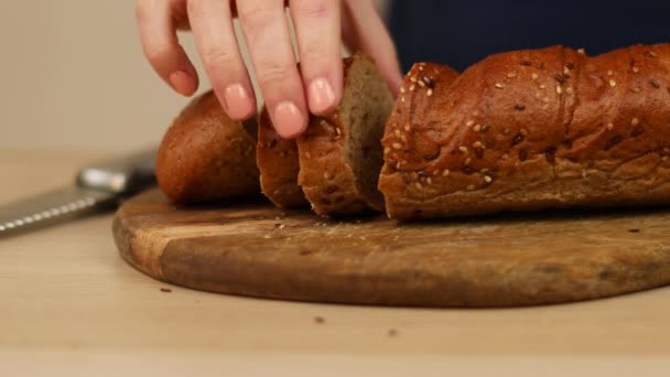 Mulher tomando fatia de saboroso pão de centeio caseiro com sementes de bordo — Vídeo de Stock