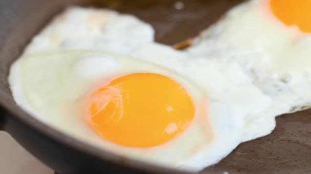 Fritar um ovo em uma frigideira em um fogão quente para o café da manhã — Vídeo de Stock