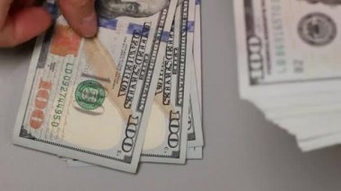 İş kadını elinde yeni 100 dolarlık banknotlar tutuyor. Kadın parayı sayıyor..