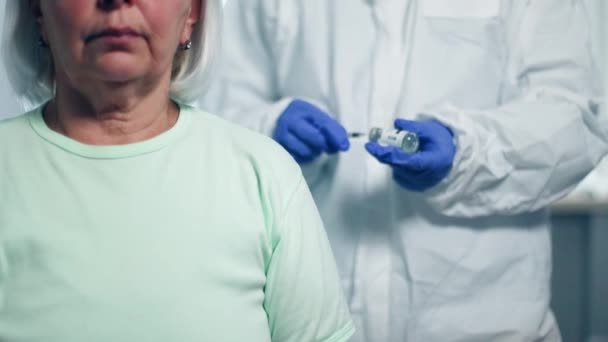 Врач делает вакцинацию пожилой женщине — стоковое видео