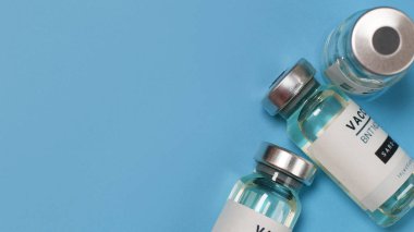 Coronavirus covid-19 deneysel aşı şişeleri mavi üzerine kopyalanmış bir laboratuvar.