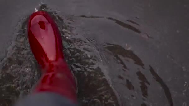 Femme en caoutchouc rouge bottes imperméables marche à travers les flaques de boue d'automne par temps froid — Video