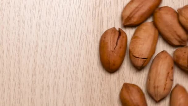 Pekan ořechy v tvrdé skořápce s prasklinami na stole. Koncept potravin. — Stock video