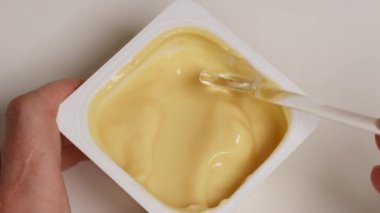 Lezzetli vanilyalı pudingi beyaz masadaki kaşıkla karıştırıyorum. Tatlı krema, lezzetli tatlı.