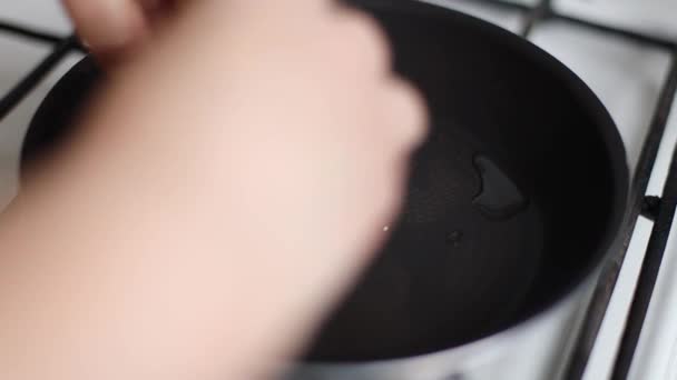 Close up of hands making fried eggs in black frying pan. Breakfast concept. Broken egg falls into the frying pan — Stock Video