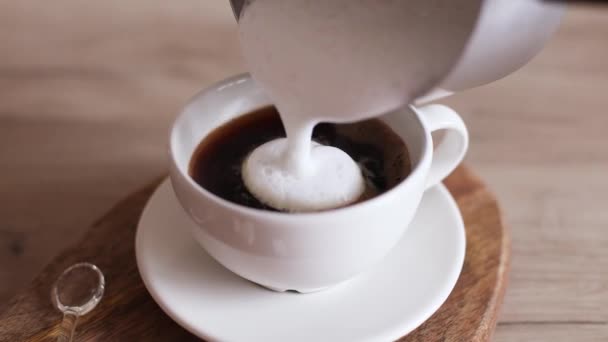 A womans hand pours whipped milk into a ceramic cup in the kitchen. A charge of vivacity every day. Tasty breakfast — Video Stock