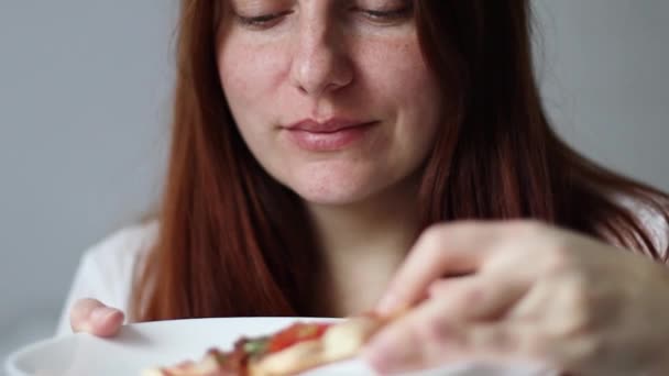 Una mujer graciosa comiendo un pedazo de pizza italiana. Mujer hambrienta, de cerca — Vídeos de Stock