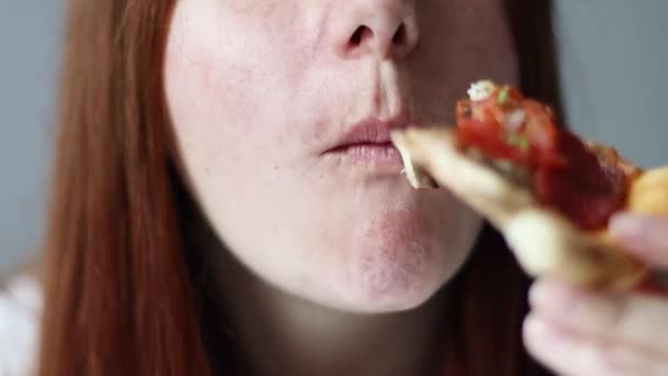 陽気な女性はおいしいイタリアのピザを食べ、ファーストフードのおいしいスライスを楽しんでいます。餓鬼女 — ストック動画