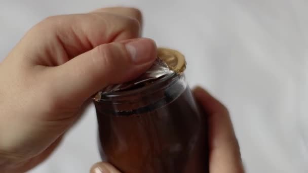La mano del hombre abre un frasco de vidrio en un yogur de crema de chocolate — Vídeos de Stock