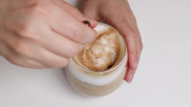 Blick von oben auf Person, die Latte-Kaffee mit Löffel umrührt — Stockvideo