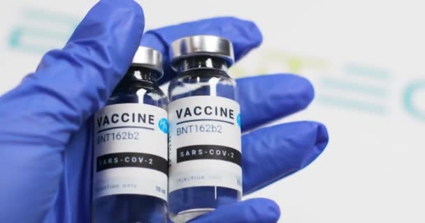 Odessa, Ukraine - 9. Dezember 2020: In der Klinik hält ein Arzt Hand in Hand ein neues Coronavirus covid 19 Impffläschchen mit transparenter Flüssigkeit in der Hand. Entwicklung und Entwicklung der Medizin — Stockvideo