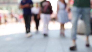Bir kalabalık cadde boyunca yürüyor. İş çıkış saati, kapalı ayaklar, güneşli bir yaz gününde şehir sokaklarındaki kadınlar. Bulanık insanlarla şehir manzarası