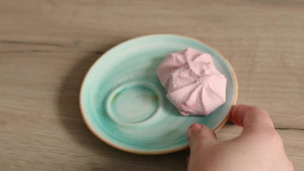 Xícara de café preto com sobremesas de marshmallow em uma mesa de madeira. Delicioso marshmallow de mirtilo soprado em pires — Vídeo de Stock