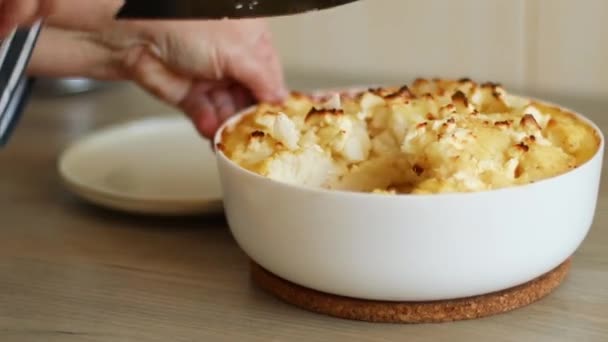 Zelfgemaakte seizoensgebonden bloemkool ovenschotel. Hand snijdt een stuk taart — Stockvideo