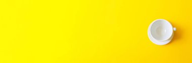 Sarı arka planda boş beyaz seramik bardak. Sabah kahvaltısı, kahve ya da çay içmeyi.