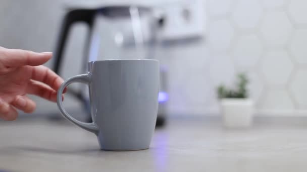 La main de la personne prend une tasse de café chaud ou de thé de la table dans la cuisine. Fille profiter du petit déjeuner en vacances matin vacances à la maison — Video