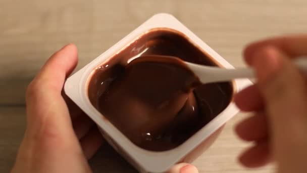 Erkek eli yakın, lezzetli bir çikolatalı mus ya da plastik kavanozda kaşıklı puding alın. — Stok video