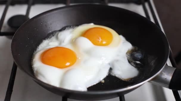 Close up of fried eggs in black frying pan. Breakfast concept. — Stock Video