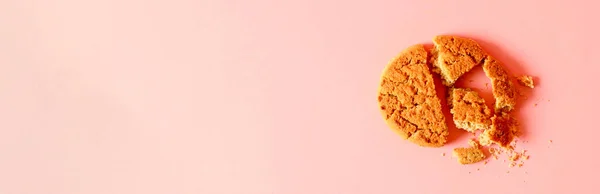 Homemade chip cookies and crumbs isolated on pink background. Minimal composition. Flat lay, top view