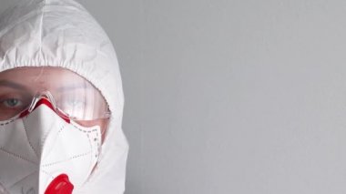 Coronavirus, hastalık, enfeksiyon, karantina, tıbbi maske gibi hastalıklara karşı korunmak için tıbbi maske, gözlük ve koruyucu beyaz iş giysisi giyen bir sağlık görevlisi.