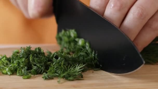 Couper un bouquet d'aneth vert frais avec un couteau sur une planche de bois. Concept de récolte — Video