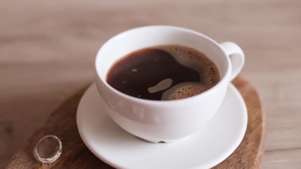 Taza de café aromático con humo natural de vapor de café sobre fondo de mesa de madera — Vídeo de stock