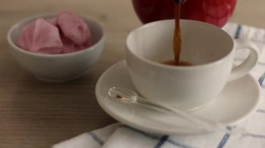 Bir fincan sade kahve ve ahşap bir masada şekerleme tatlısı. Tahta bir masaya Türk kahvesi döküyorum..