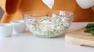 Sarımsak ve ottan ev yapımı süzme peynir yapan kadın eller..