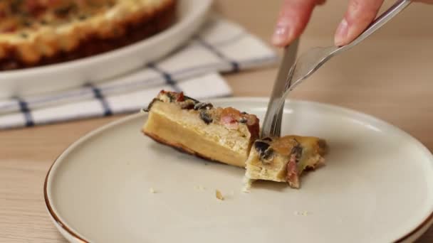 Nahaufnahme Person Hand nehmen mit der Gabel Stück hausgemachte offene Torte mit Speck, Pilzen und Zwiebeln auf dem Tisch. Kuchenstück auf einem weißen Teller. Torte mit Huhn. Chicken pie. — Stockvideo