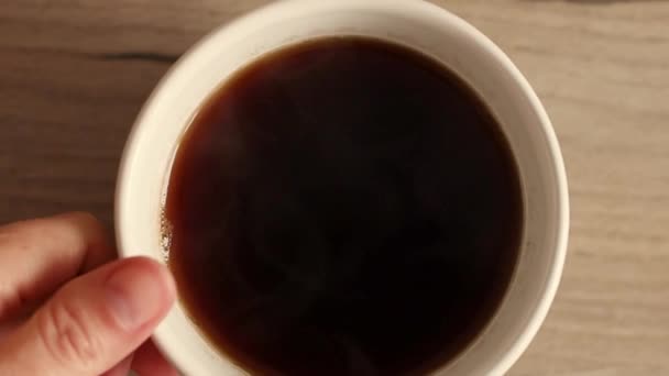 Närbild av kvinnliga händer ta en kopp kaffe från träbord. Ovanifrån — Stockvideo