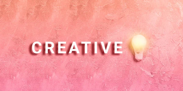 Texto creativo y bombilla iluminada sobre fondo grunge rosa. Inspiración creativa, concepto de ideas de planificación. Piso tendido, vista superior — Foto de Stock