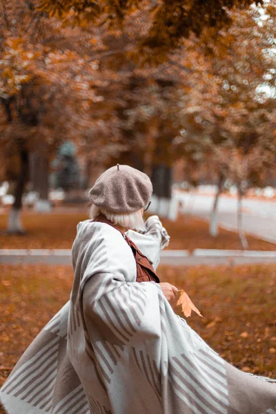 Femme caucasienne au béret chaud français et couverture de laine tourbillonne et profite dans le parc. Saison d'automne. Le bonheur — Photo