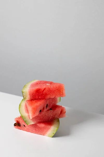 A bunch of triangular pieces of watermelon on the table. Vertical orientation — Stock Photo, Image