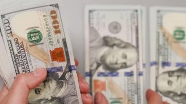 İş kadını ya da erkek eli Amerikan para banknotlarını sayar. Elinde yeni banknotlar var. Anlaştık, iş konsepti.
