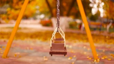 Boş tahta bebek güzel bir sonbahar parkında sallanıyor..
