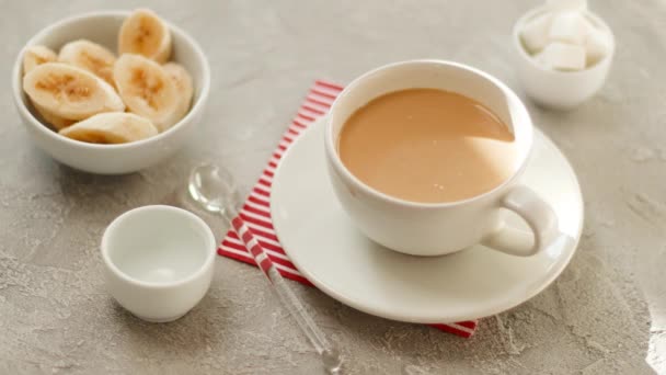 Conceptul de mic dejun sănătos. Mâna femeii ia o ceașcă de băutură fierbinte. Ceașcă de cafea cu lapte pe o masă de textură din beton gri . — Videoclip de stoc
