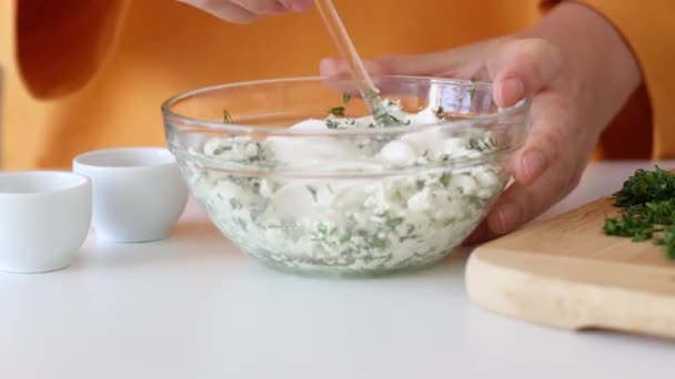 Samičí ruce, domácí tvaroh s česnekem a bylinkami. Příprava snídaně — Stock video